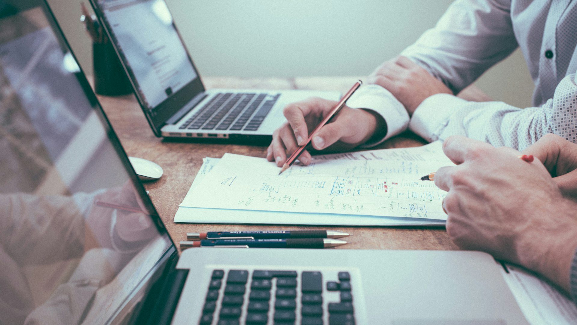 Buyers reviewing property documents beside laptops during due diligence